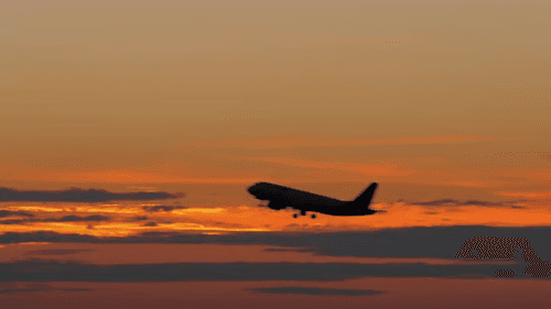 An aircraft departing against a sunset sky